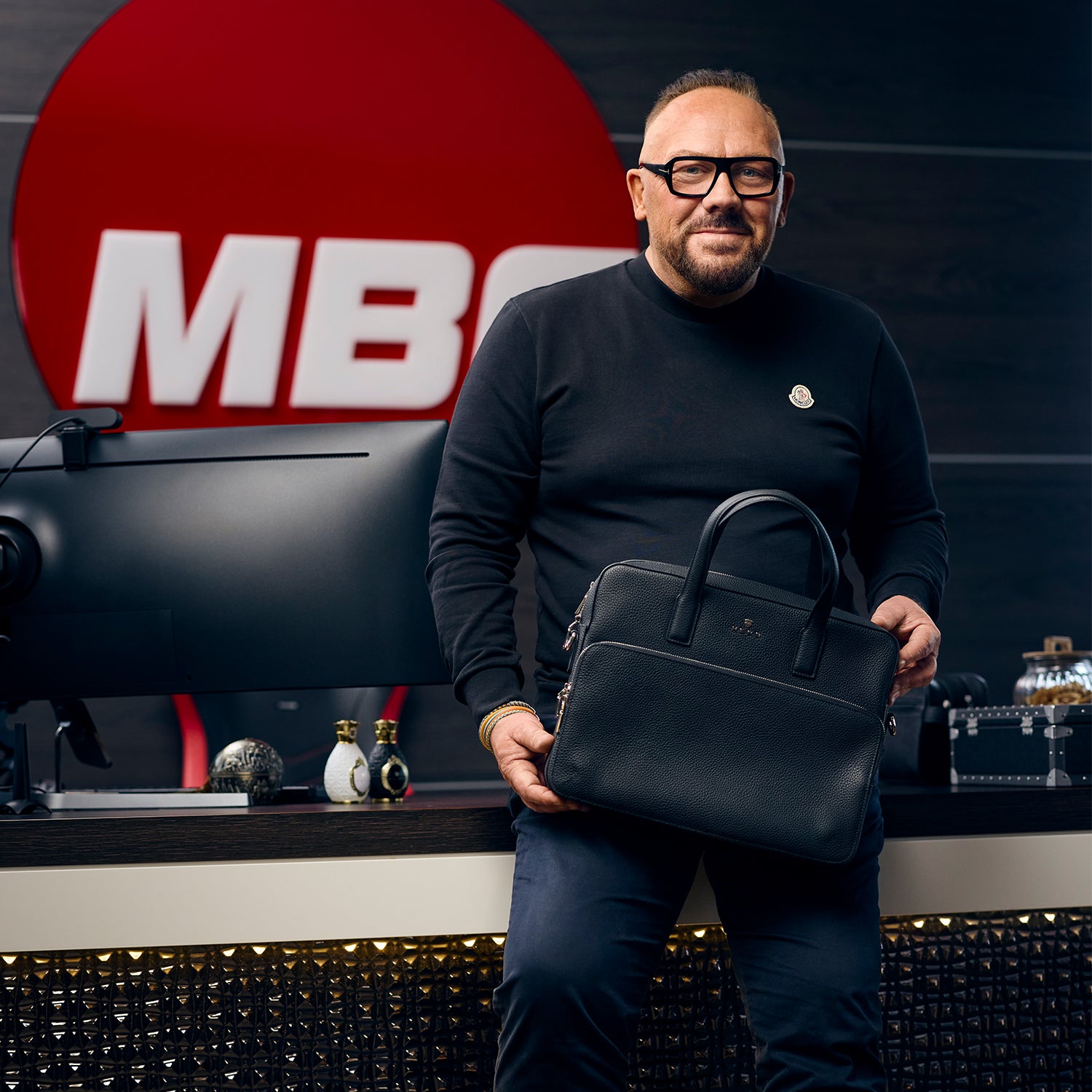 Andreas Herb mit schwarzer Business Bag aus Leder im Büro